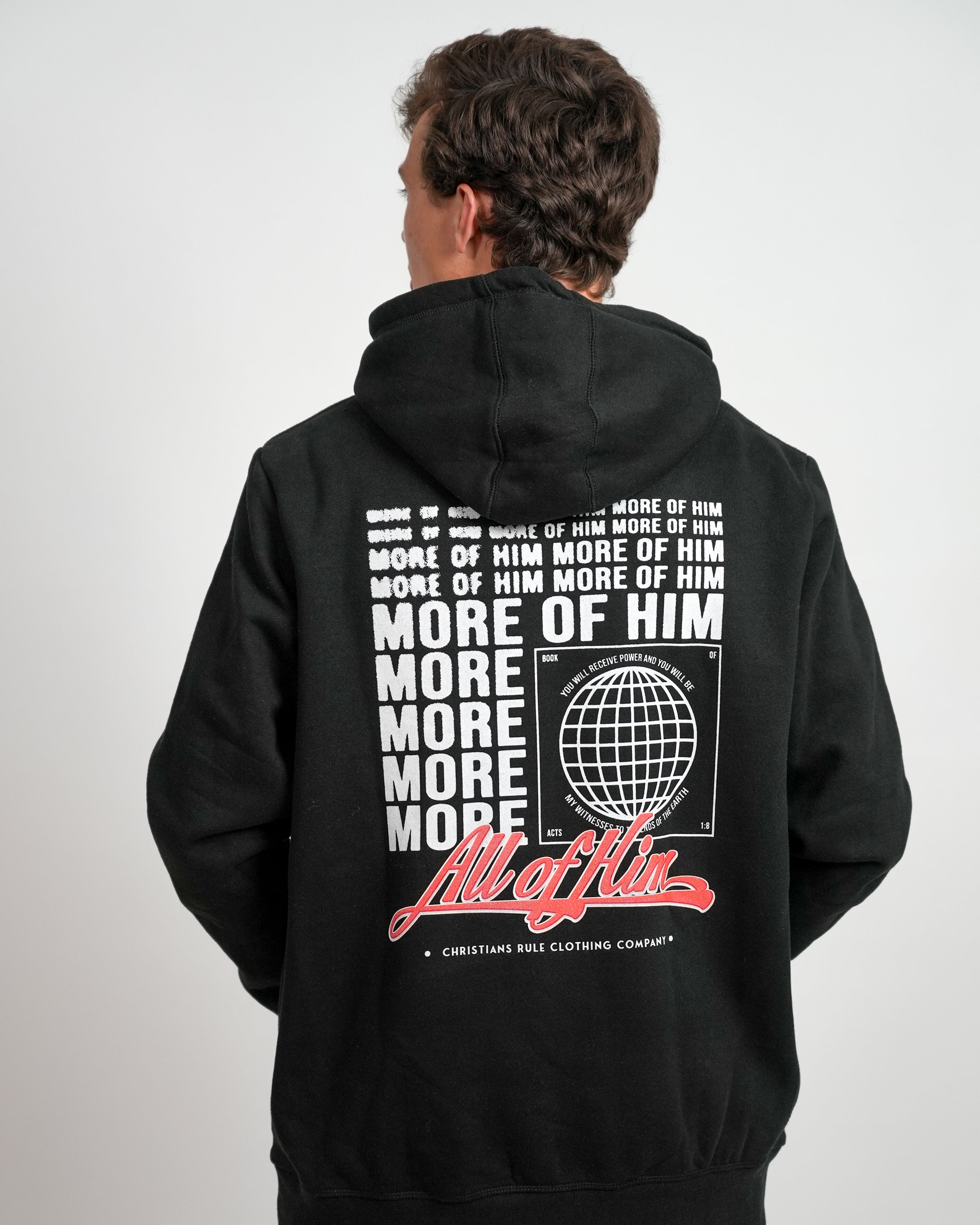 Male model wearing a black Christian hoodie with stylized 'All of Him' script graphic design, standing against a white background.