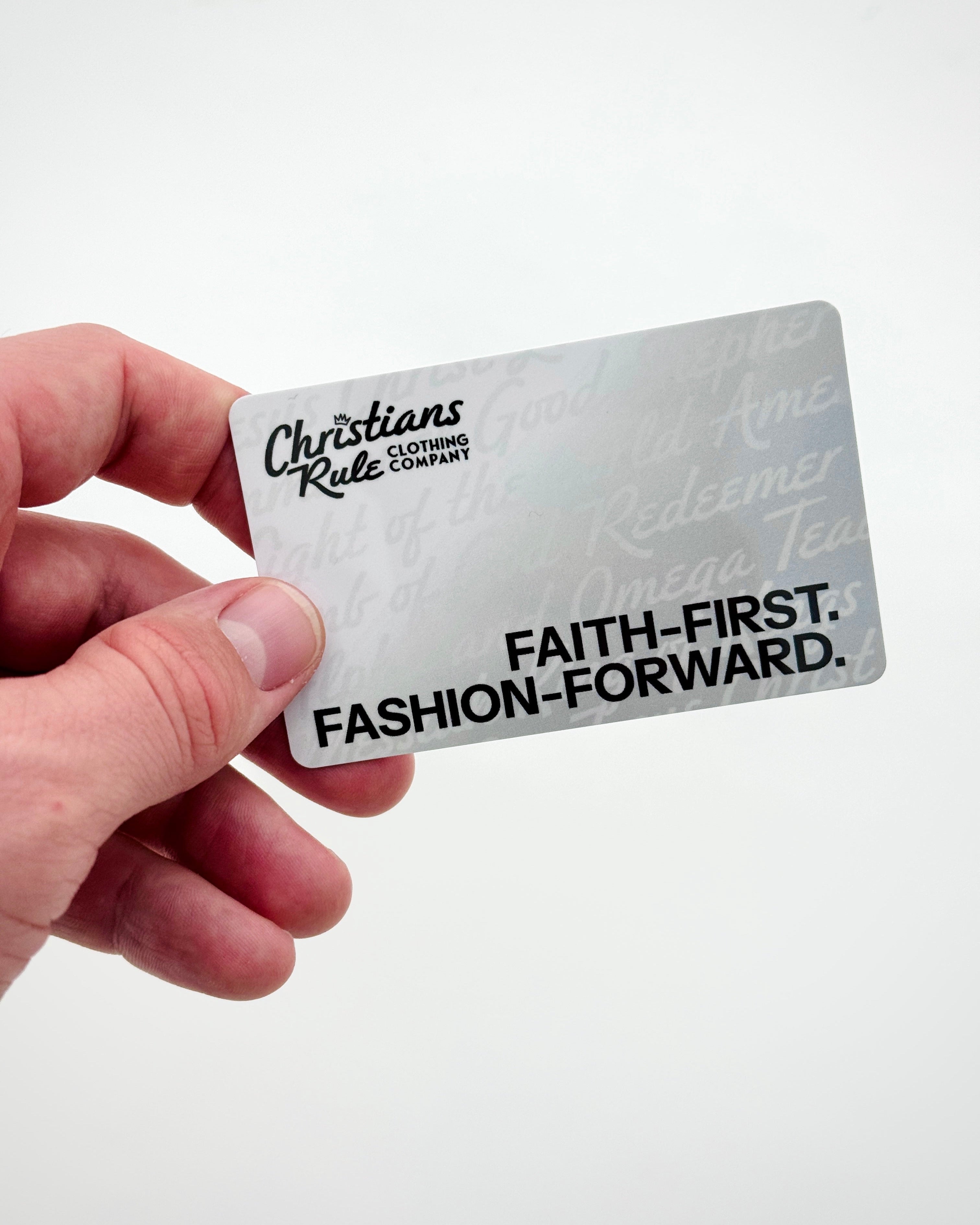 Hand holding gift card with 'Christians Rule Clothing Company' branding against a white background.